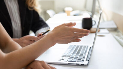 photograph-of-a-person-helping-a-woman-with-her-computer